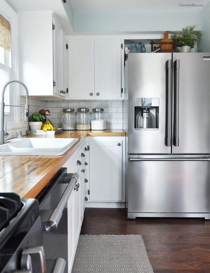This industrial farmhouse kitchen is both functional and inviting. Stainless steel appliances bring a professional industrial look while adding softer elements provides the comfort of a farmhouse. 