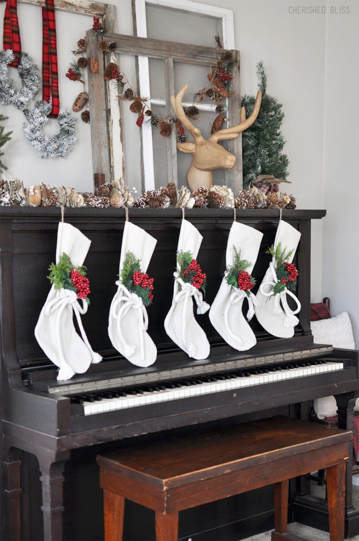 Super Cozy Christmas Mantel with drop cloth stockings, mini wreaths, pine cones, and a deer head! 