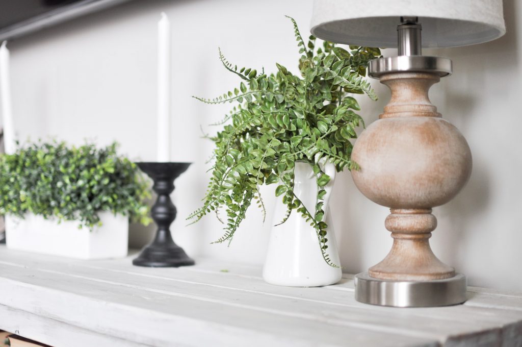 This Simple Summer Mantel is decorated using simple whites and greens to celebrate the growth of the season mixed with a few wood tones for coziness!