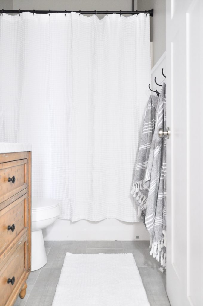 This light and airy bathroom is the perfect way to transform a small stuffy space into something you will love. Visit the post to get all the details on this Modern Farmhouse Bathroom.