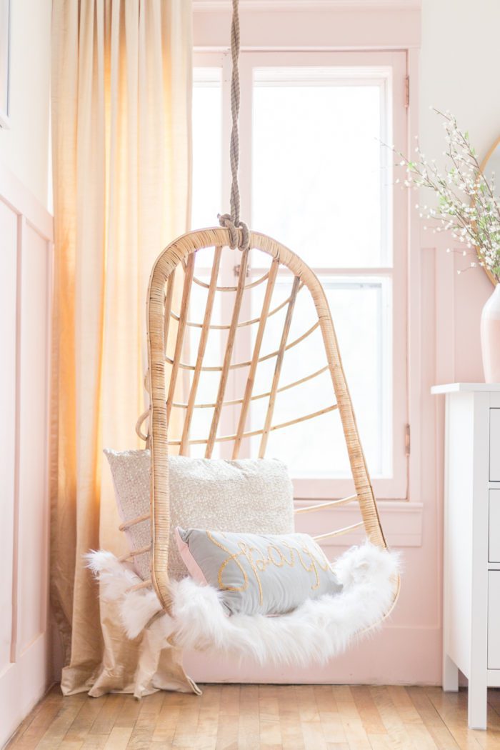 hanging wicker chair in pink and gold girls bedroom