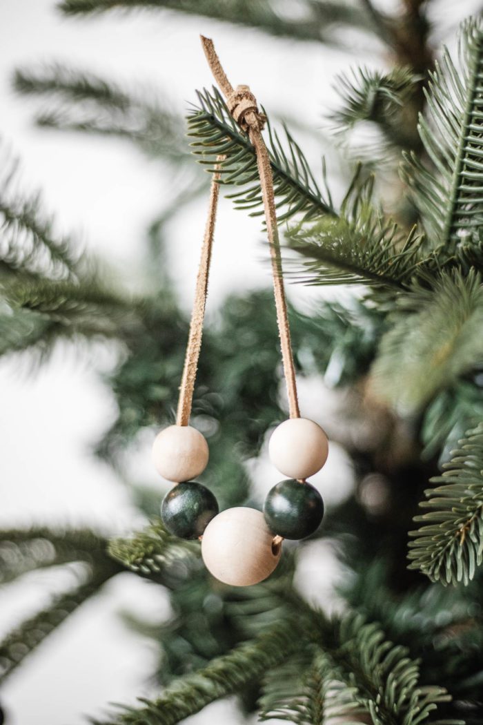 Wooden Bead Christmas Ornament with leather lacing hanging on Christmas Tree. 