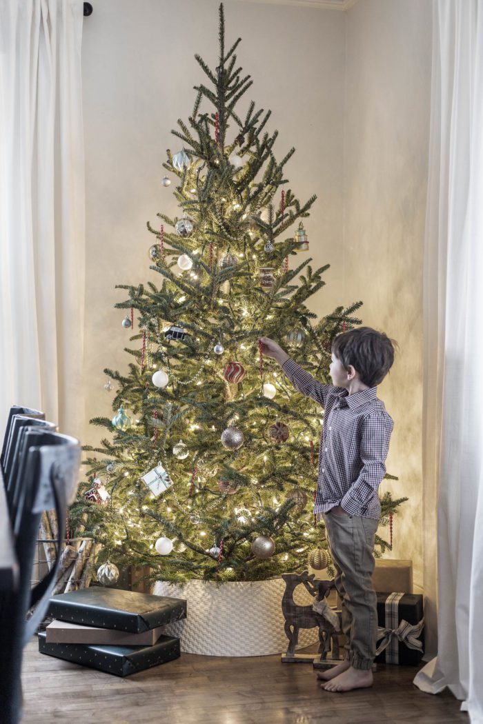 little boy decorating a nostalgic Christmas tree - the perfect holiday tradition. 