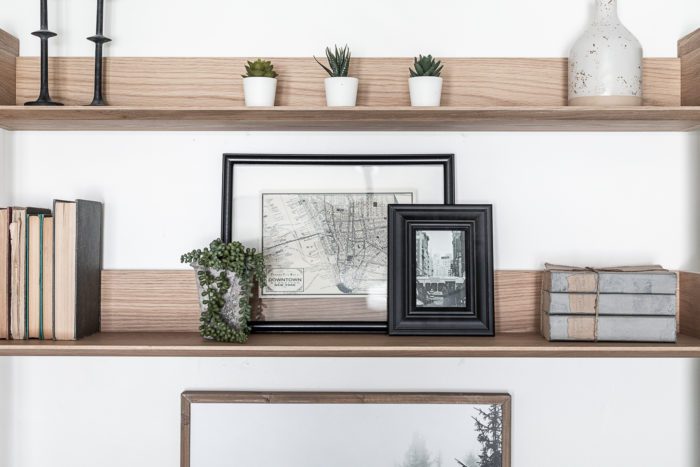 Desk Shelf Styling with black frames, books, and faux greenery. 