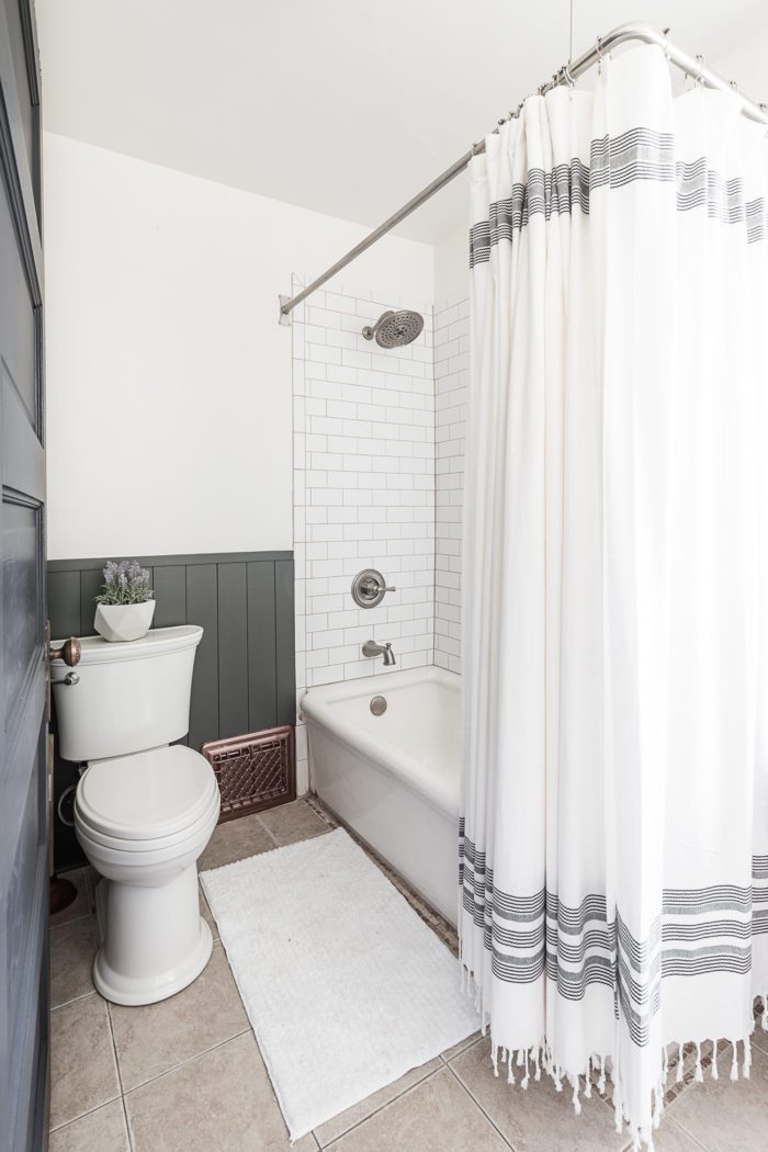Bathtub with two open sides and subway tile. 