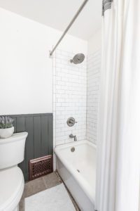 Boys Bathroom with dark green vertical shiplap and subway tile in shower