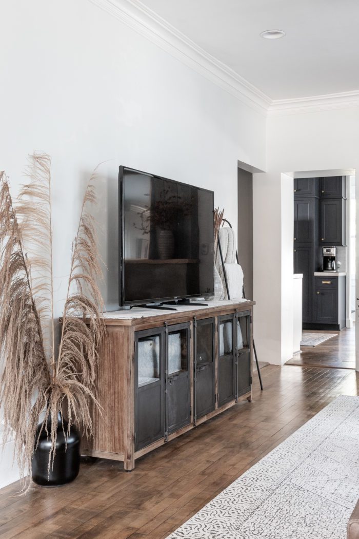 Media unit with tv and tall Uva Grass is black glass jug. 