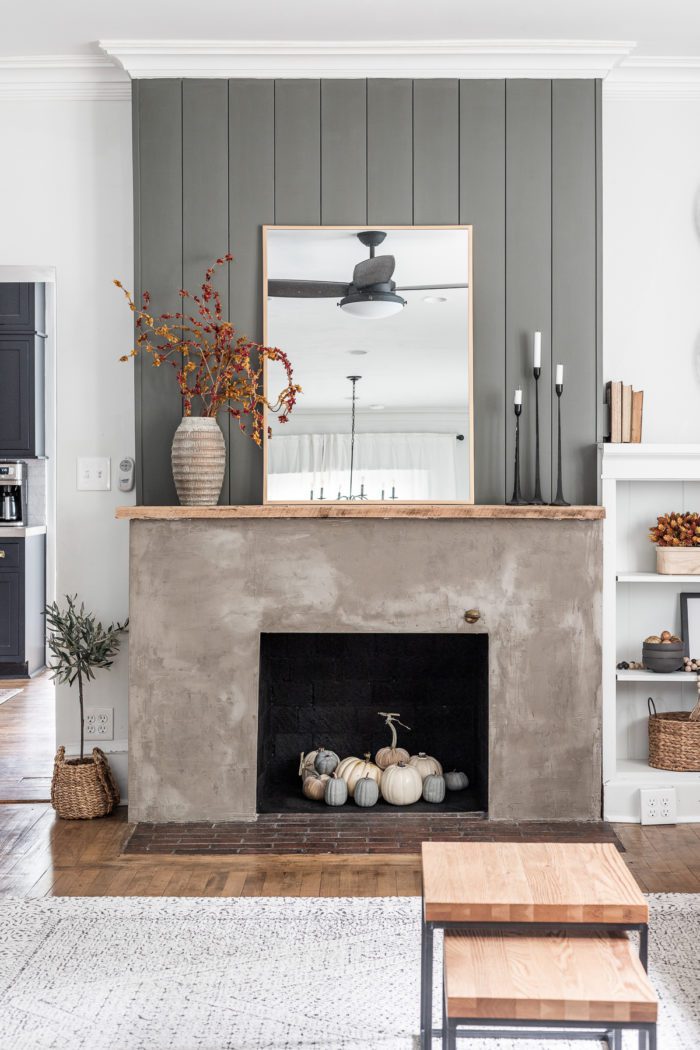 Concrete fireplace with vertical shiplap decorated for Fall. 