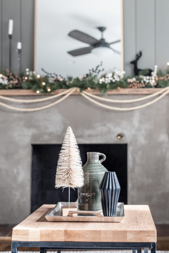 Winter Decor Items on Coffee Table in front of concrete fireplace. 