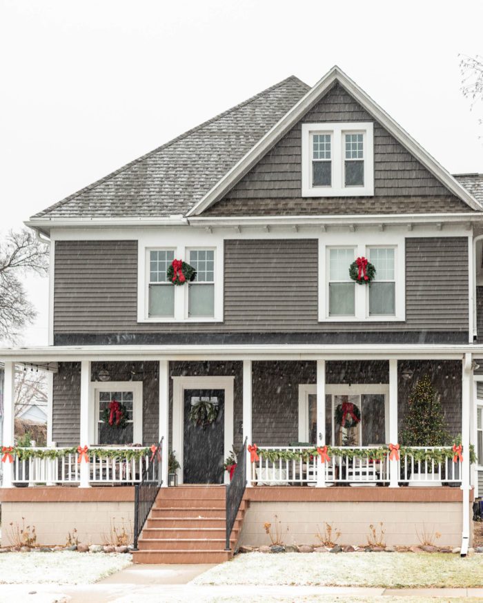 Dark Gray house with Christmas Wreaths on windows. 