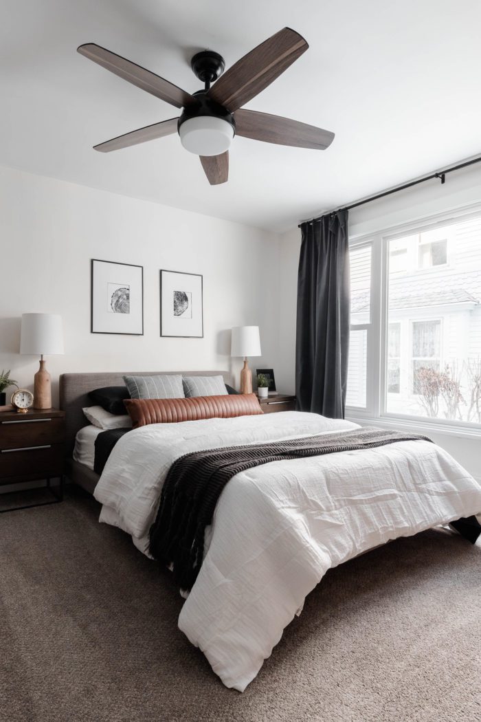 How to Make Your Bed like a Designer - The Streamlined looks featuring clean lines. Queen size bed with a modern gray headboard, white bedding, dark gray accents and a leather lumbar pillow.