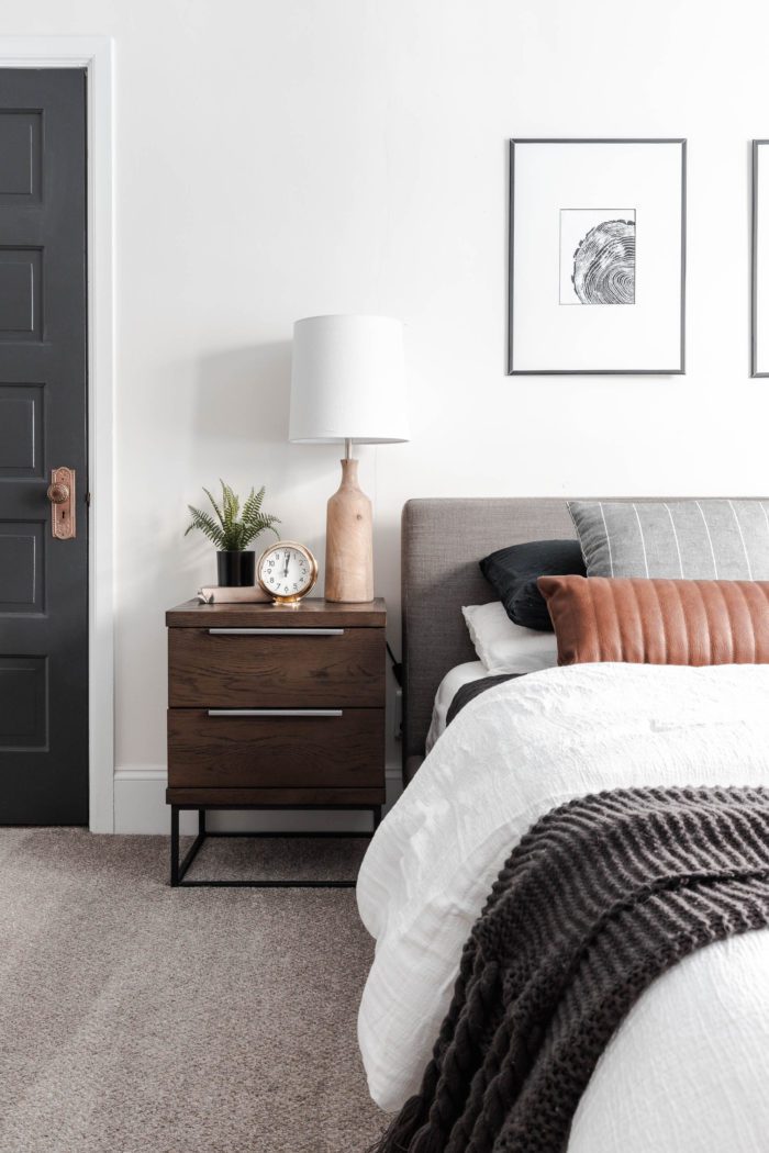 How to Make Your Bed like a Designer! Queen size bed with a modern gray headboard, white bedding, dark gray accents and a leather lumbar pillow.