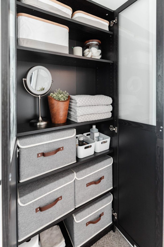 Storage bins used inside of an Ikea Billy Bookcase to create functional organization when your bathroom lacks storage. 
