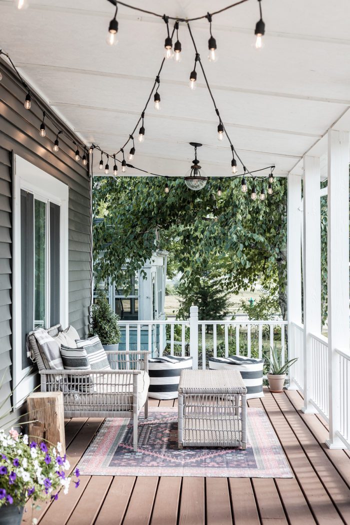 Summer Outdoor Furniture on front porch with rug and flowers