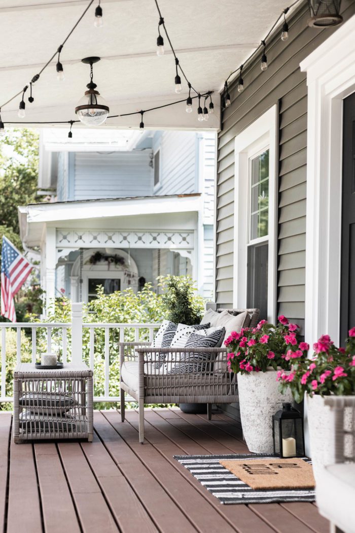Front porch with white planters, loveseat and coffee table - Easy Summer Porch Decor Ideas