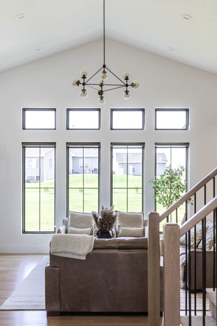Tall Black Windows in a great room with cathedral ceilings decorated for Fall. 